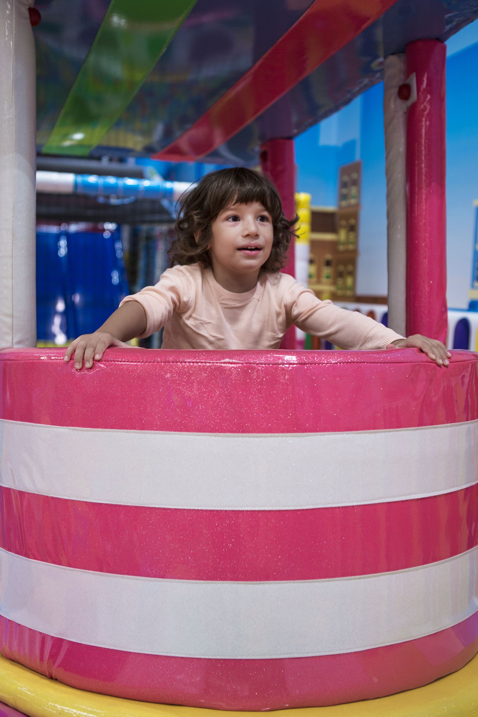 Happy little boy have Fun in the pool of colorful balls .